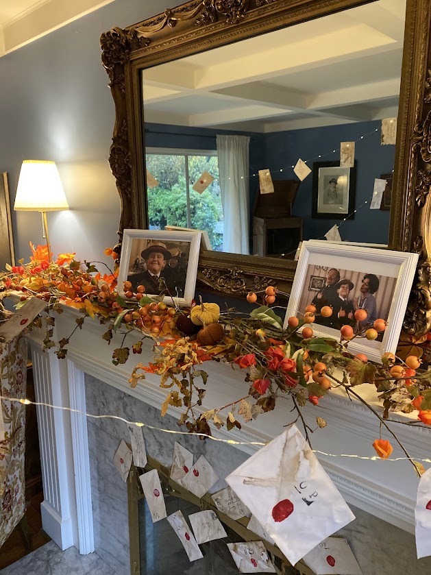 The Dursley's mantle at Number 4 - Privet Drive with pictures of the Dursley family including Dudley Dursley, Vernon Dursley, and Petunia Evans Dursley for a Harry Potter party inspired living room