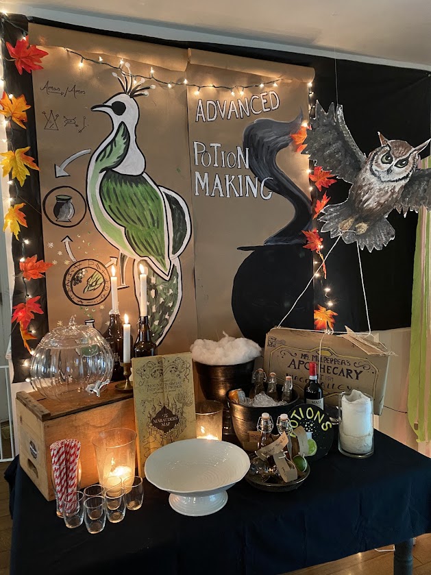 Harry Potter party bar set up as potions classroom with spells, owls, bubbling cauldrons, butterbeer, candlesticks, potions, glasses, straws, The Marauders map