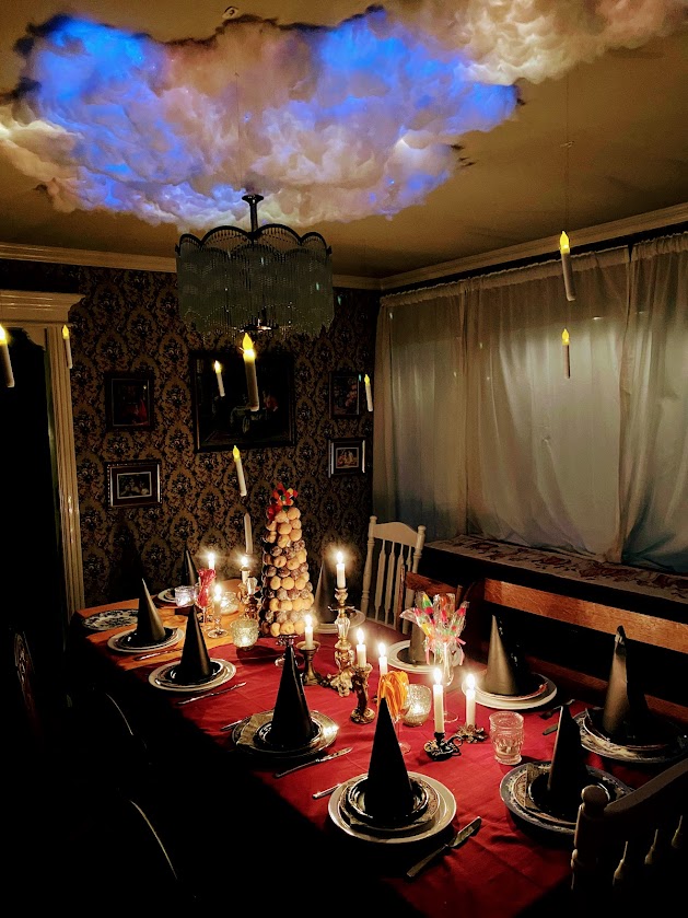 Grand Hall from Hogwarts dinner table setting below enchanted ceiling with floating candles and witches hats